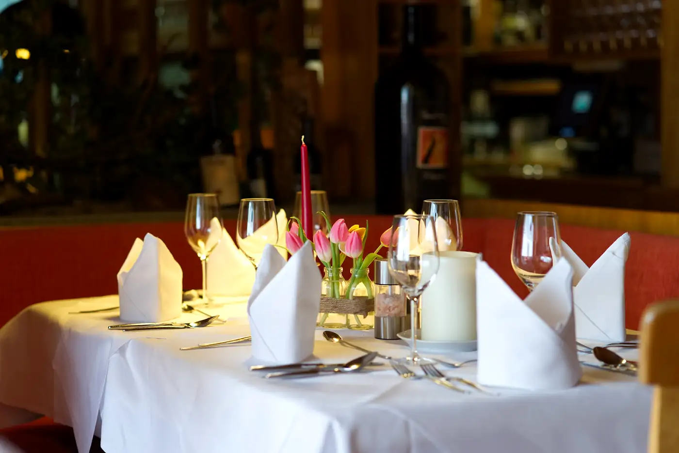 Gedeckte Tafel mit Kerzen, Tulpen und Servietten in der Stube